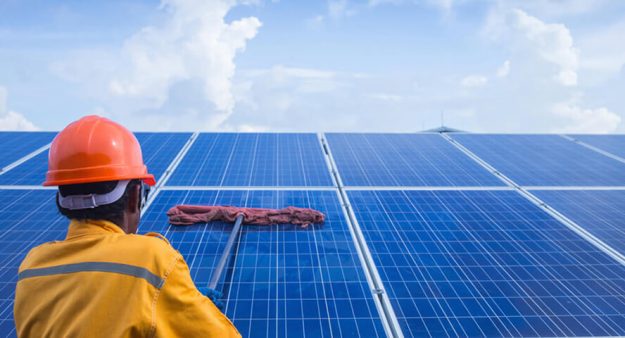 Why You Should Clean Your Panels this Spring A man cleaning the solar panels