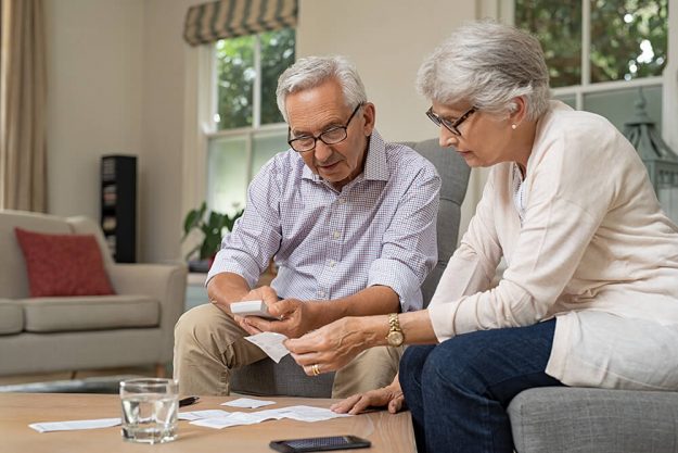 An elderly couple sitting in the couch